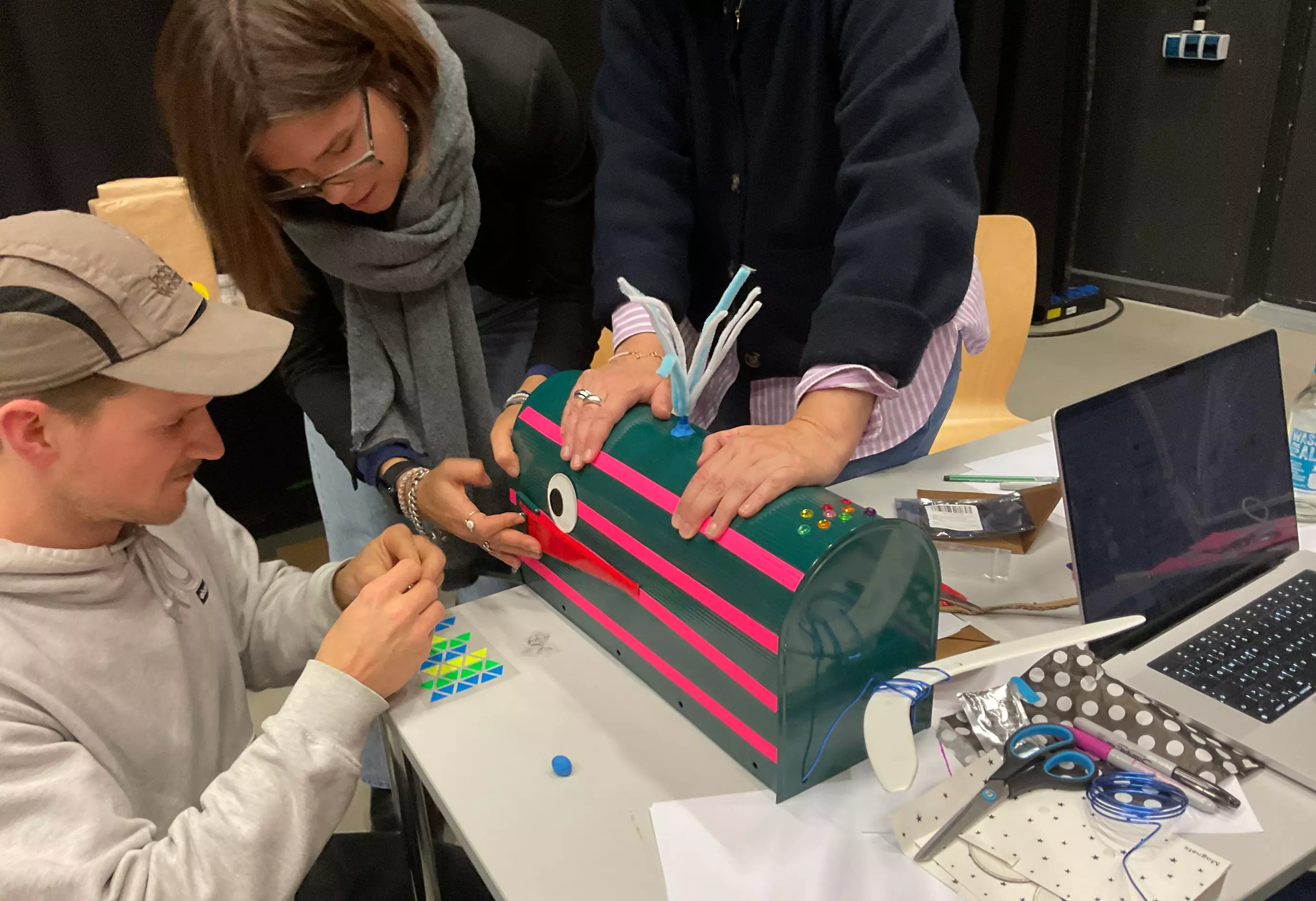 Zwei Personen an einem Tisch arbeiten an einem Tisch an einem Prototypen. Foto: Astrid Csuraji