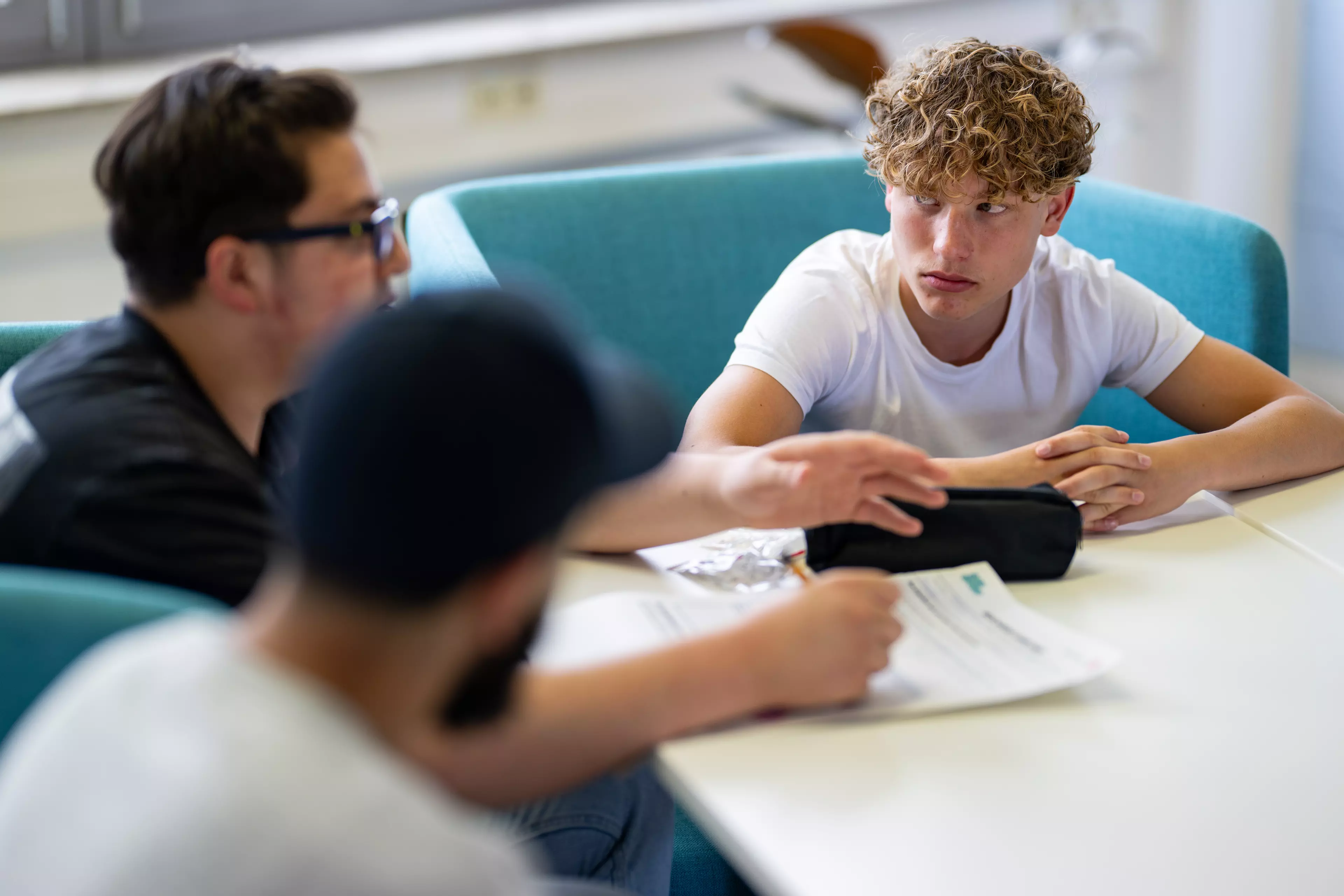 Jugendliche beim Brainstormen an einem Tisch. Foto: Markus Hertrich